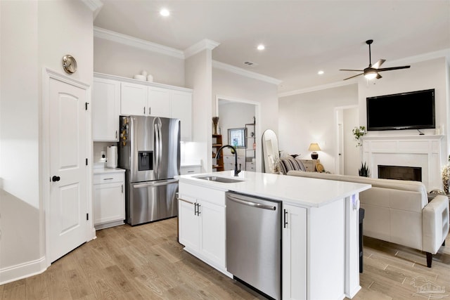 kitchen featuring sink, appliances with stainless steel finishes, white cabinetry, light hardwood / wood-style floors, and an island with sink