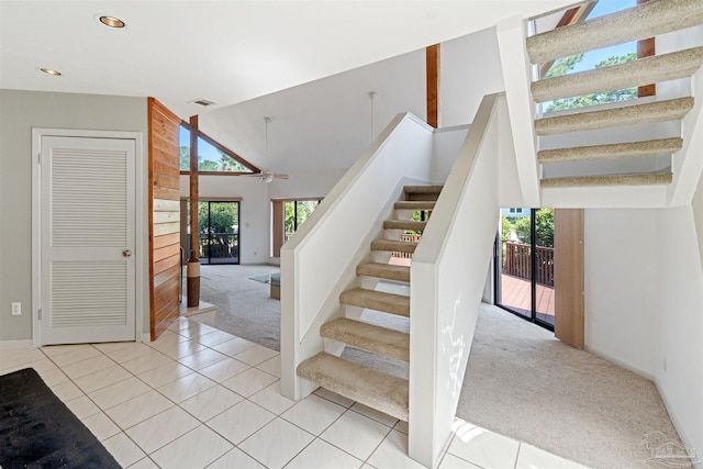 stairs featuring high vaulted ceiling, carpet, and ceiling fan