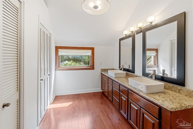 bathroom with vanity, lofted ceiling, and hardwood / wood-style floors