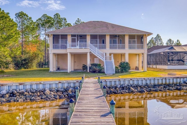 back of house with a water view, ceiling fan, and a lawn