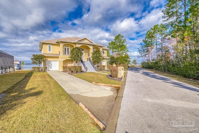 view of front facade with a water view, a garage, and a front yard