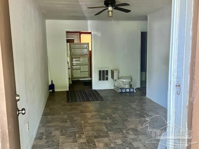 living room featuring ceiling fan and dark tile patterned flooring