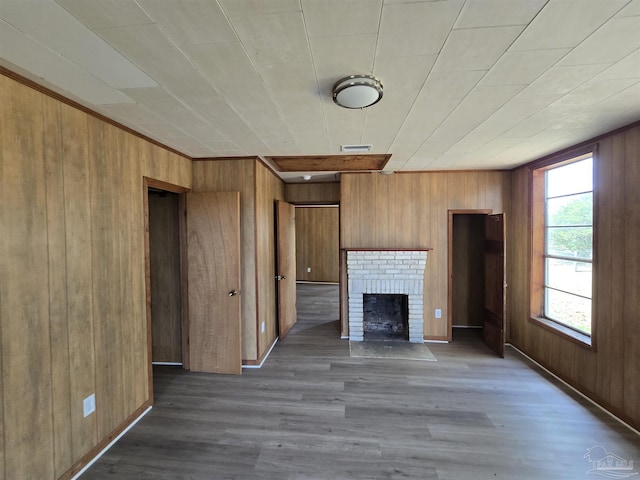 unfurnished living room with wooden walls and dark wood-type flooring