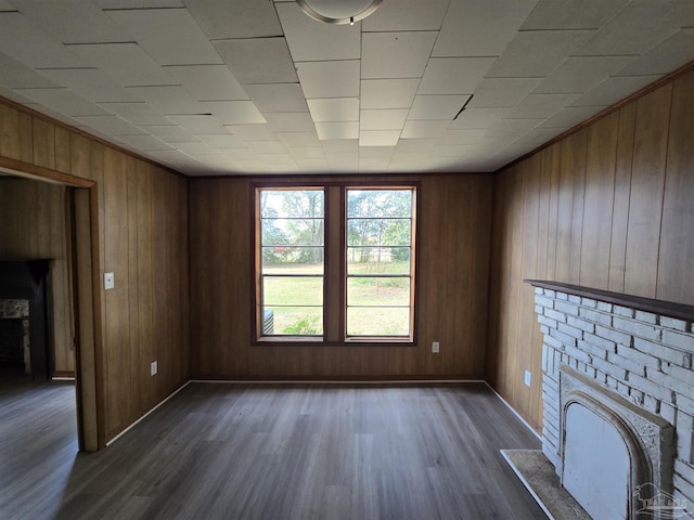 unfurnished living room with dark wood-type flooring and wood walls