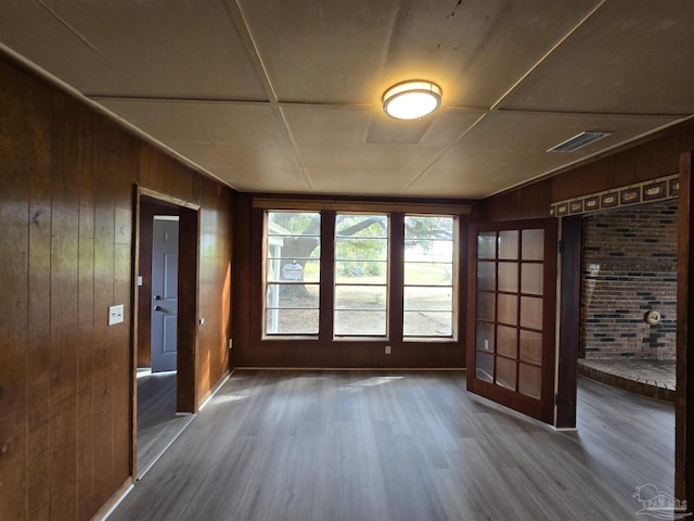 interior space with dark hardwood / wood-style floors and wood walls