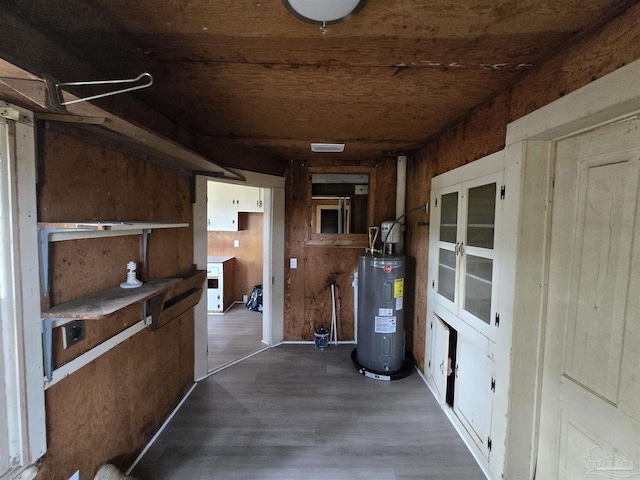 interior space with water heater, wood walls, and dark hardwood / wood-style floors