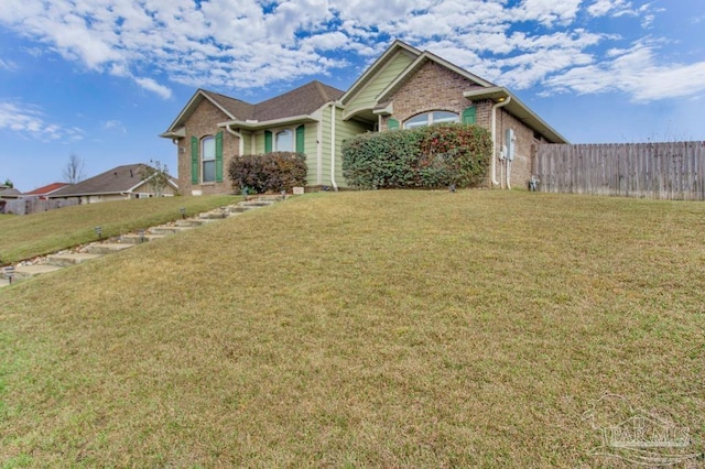 single story home with brick siding, a front lawn, and fence