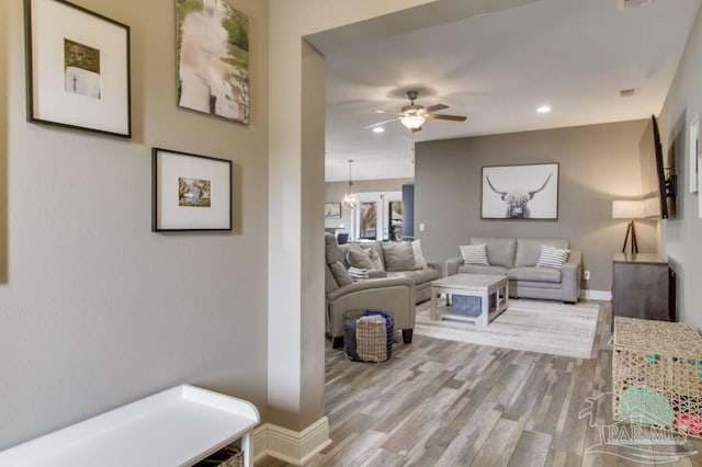 living room featuring light wood-style floors, recessed lighting, baseboards, and a ceiling fan