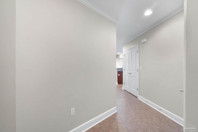 hall featuring light tile patterned floors and crown molding