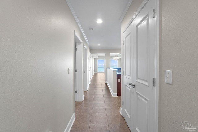 corridor featuring light tile patterned flooring and ornamental molding