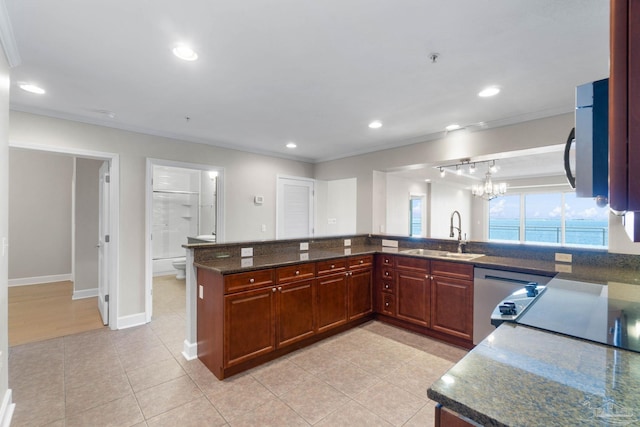 kitchen with an inviting chandelier, a water view, sink, light tile patterned floors, and appliances with stainless steel finishes