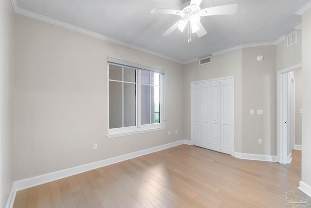 unfurnished bedroom with ornamental molding, a textured ceiling, ceiling fan, light hardwood / wood-style flooring, and a closet