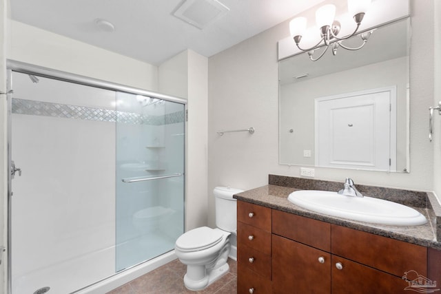 bathroom featuring tile patterned floors, vanity, a shower with door, a chandelier, and toilet