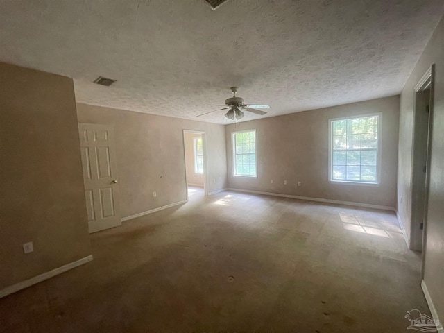 empty room with ceiling fan, a textured ceiling, and light colored carpet