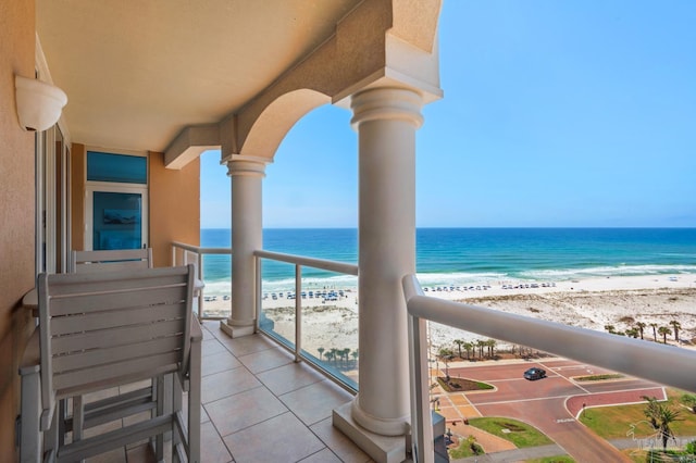 balcony featuring a beach view and a water view