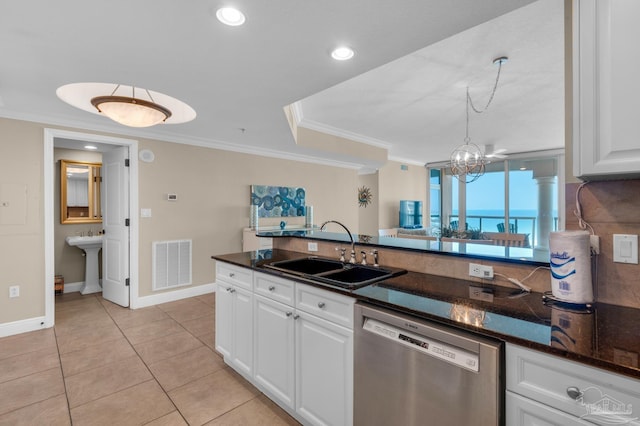 kitchen with sink, ornamental molding, dishwasher, dark stone counters, and white cabinets