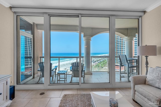 tiled living room featuring crown molding, a water view, and plenty of natural light