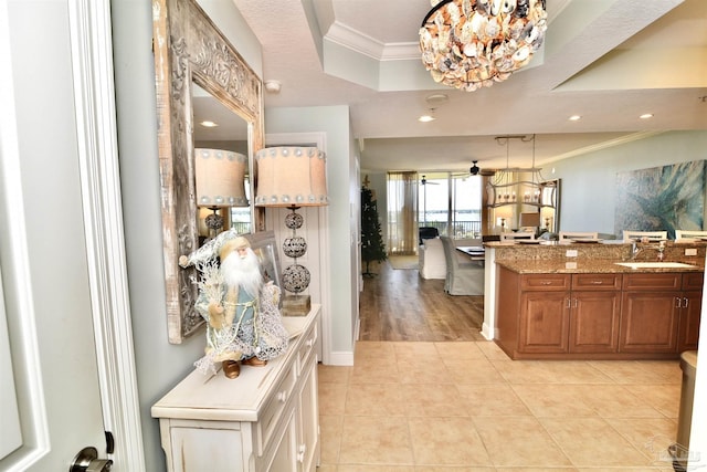 645 Lost Key Dr Unit 406D, Perdido Key, FL 32507 - interior space with brown cabinets, light tile patterned floors, a sink, crown molding, and a notable chandelier