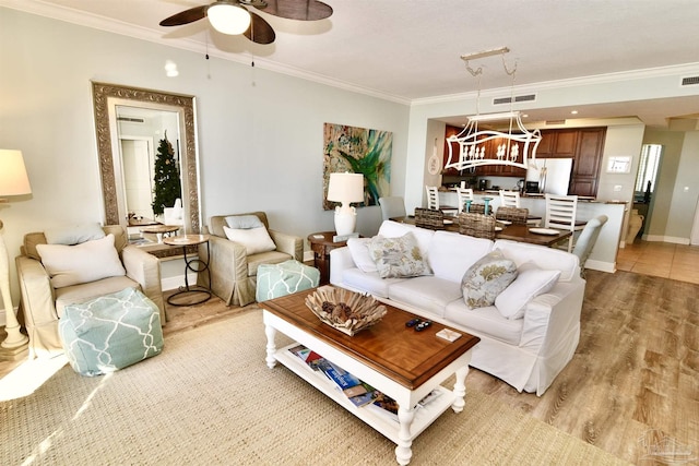 645 Lost Key Dr Unit 406D, Perdido Key, FL 32507 - living area featuring light wood-style flooring, visible vents, ornamental molding, and ceiling fan with notable chandelier