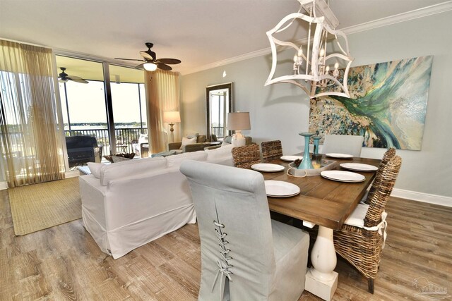 645 Lost Key Dr Unit 406D, Perdido Key, FL 32507 - dining space with baseboards, ceiling fan with notable chandelier, crown molding, and wood finished floors