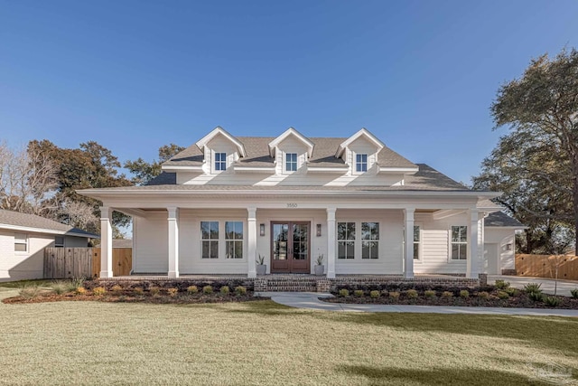 view of front of home featuring a front lawn, covered porch, and french doors