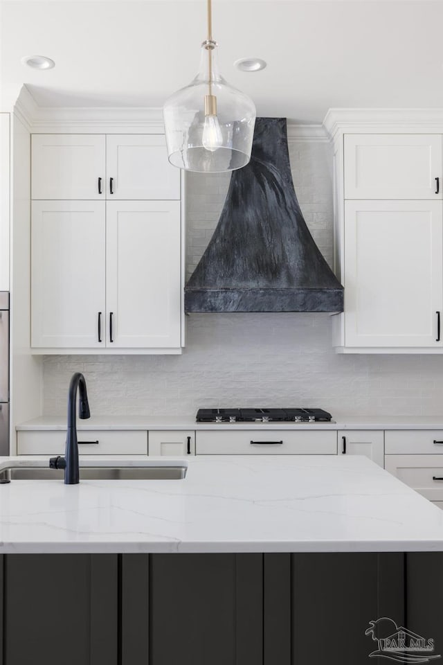 kitchen featuring sink, custom exhaust hood, white cabinetry, black gas cooktop, and light stone countertops