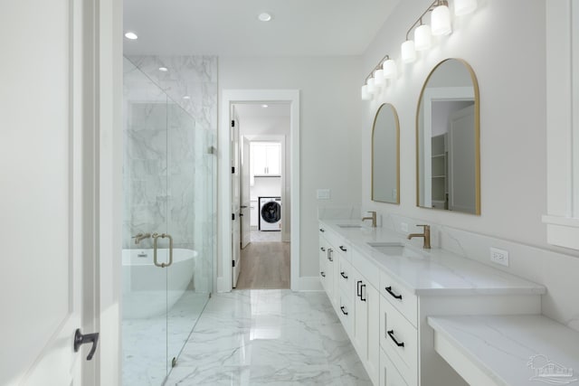 bathroom with vanity, washer / dryer, and a bathtub