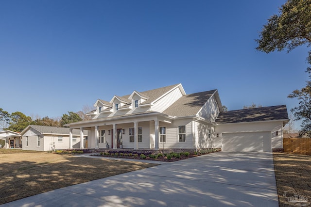 cape cod house with a garage and covered porch