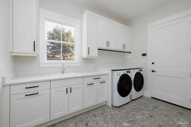 laundry room featuring separate washer and dryer, sink, and cabinets