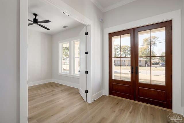 doorway with french doors, ornamental molding, and light hardwood / wood-style flooring