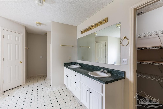 bathroom featuring a textured ceiling and vanity