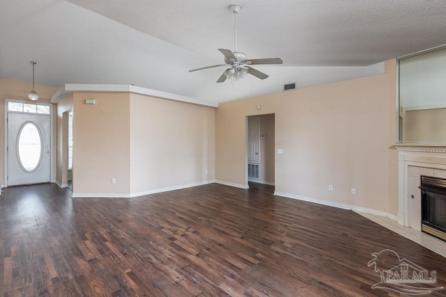 unfurnished living room featuring ceiling fan, a tile fireplace, vaulted ceiling, and wood-type flooring