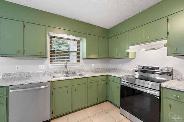 kitchen with sink, light tile patterned floors, stainless steel appliances, and a textured ceiling