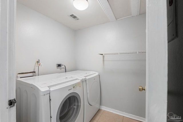 laundry area featuring washing machine and dryer and light tile patterned floors