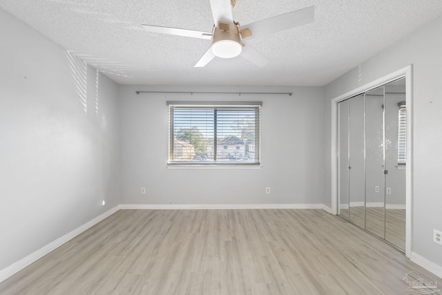 unfurnished bedroom featuring a textured ceiling, light wood-type flooring, and ceiling fan