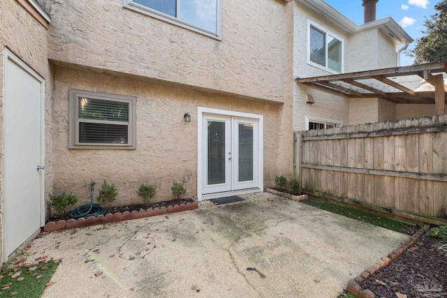 view of exterior entry featuring a patio area and french doors