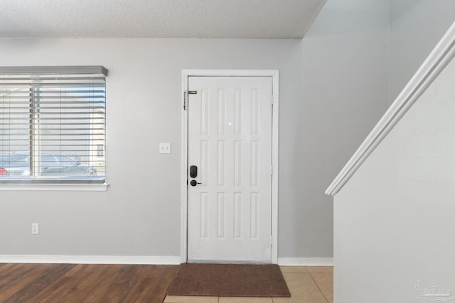 entryway featuring a textured ceiling and light hardwood / wood-style floors