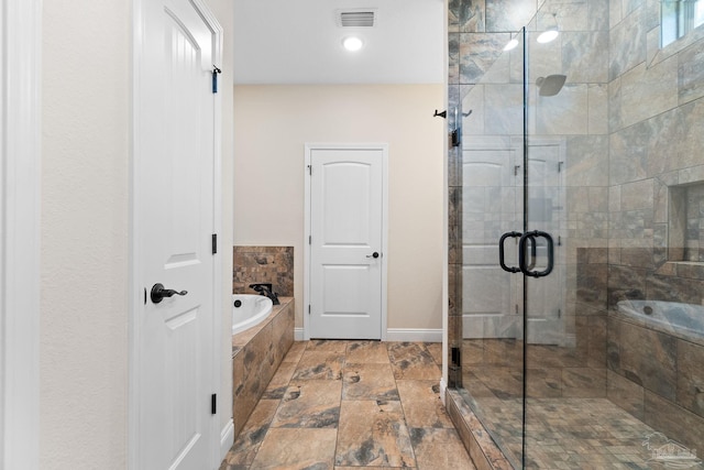 full bath with a stall shower, a bath, stone finish flooring, baseboards, and visible vents