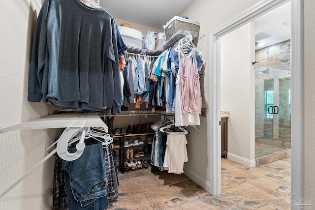 spacious closet featuring stone finish flooring