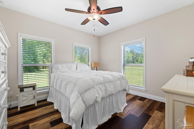 bedroom featuring dark wood-type flooring, a ceiling fan, and baseboards