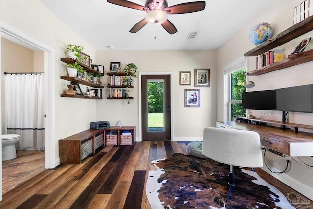 office area with baseboards, wood finished floors, visible vents, and a ceiling fan