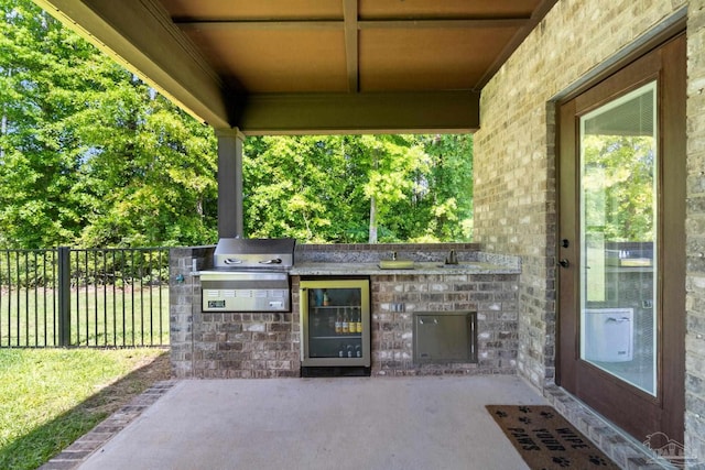 view of patio featuring a grill, an outdoor kitchen, and fence