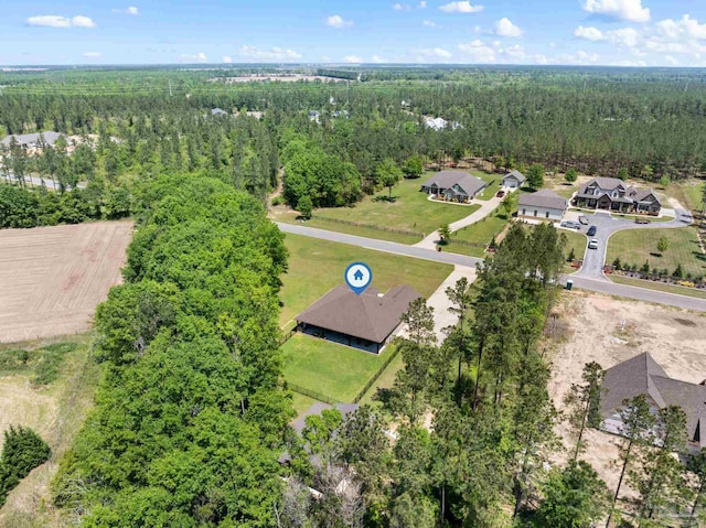 drone / aerial view featuring a residential view and a forest view