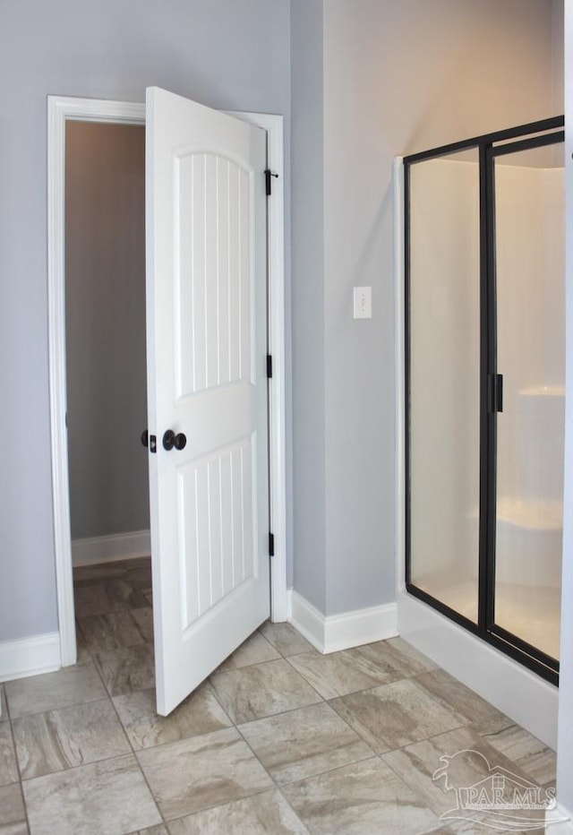 bathroom with a shower with door