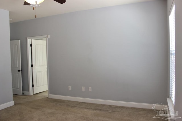 carpeted spare room featuring ceiling fan