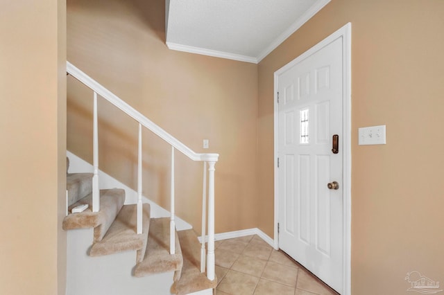 entryway with crown molding, light tile patterned floors, and a textured ceiling