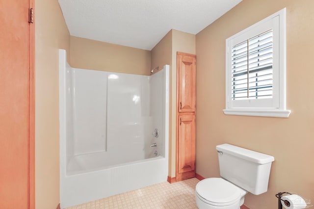 bathroom featuring shower / washtub combination, a textured ceiling, and toilet