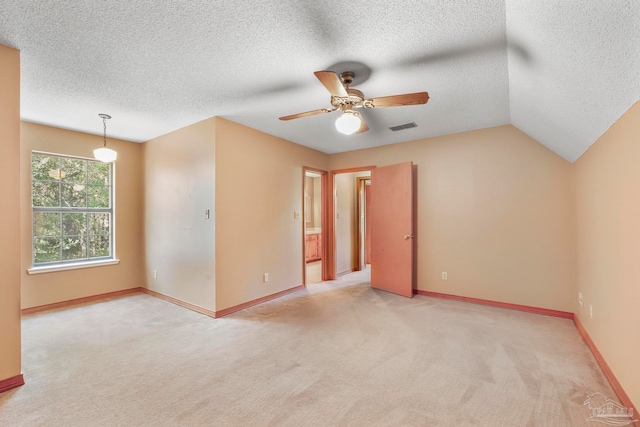 carpeted empty room featuring a textured ceiling, ceiling fan, and lofted ceiling