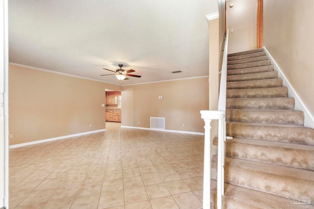 stairway with tile patterned flooring, ceiling fan, crown molding, and a textured ceiling