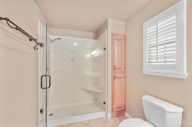 bathroom featuring tile patterned flooring, toilet, and an enclosed shower